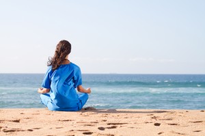young nurse meditation on beach